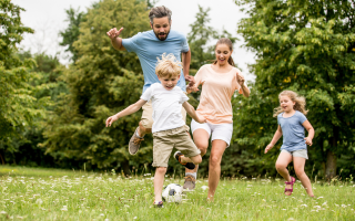 Father and kids playing soccer
